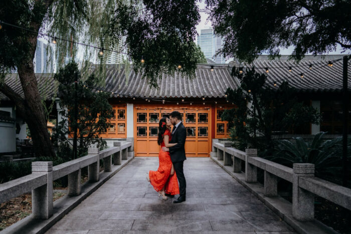 Woman in red dress dancing with groom after beautiful Chinese tea ceremony wedding