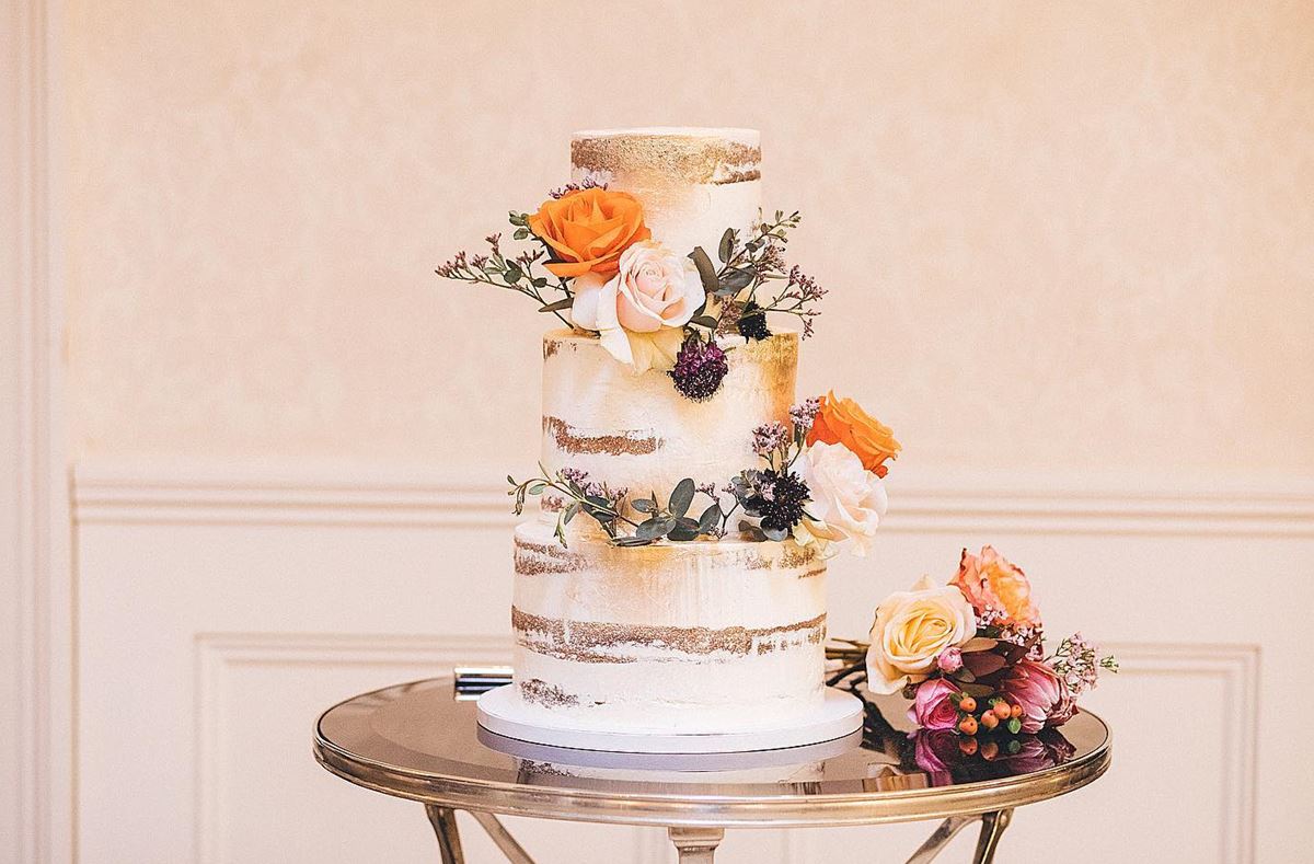 Gorgeous white wedding cake with gold leaf paint 3 layers fresh orange flowers Sydney wedding cakes maker Stacy Brewer