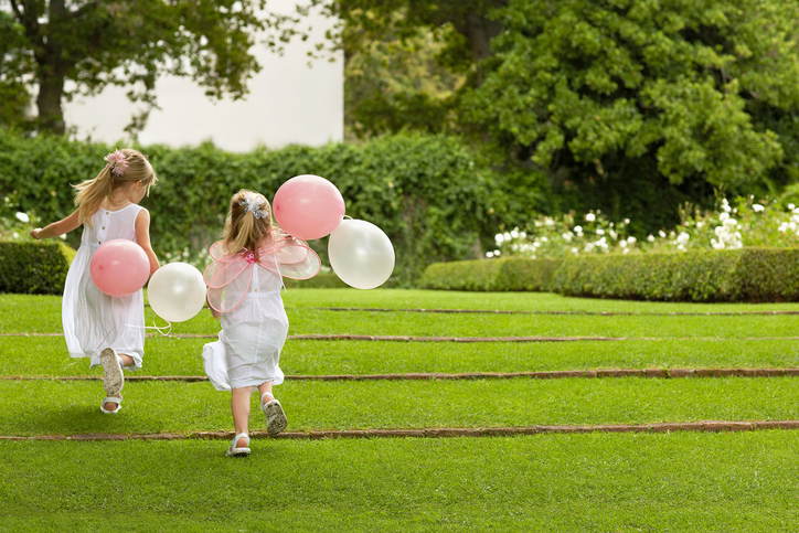 Bridesmaids With Balloons Running In Garden