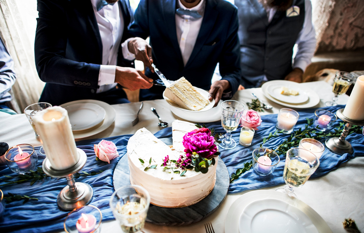 Newlywed gay couple getting cake plate