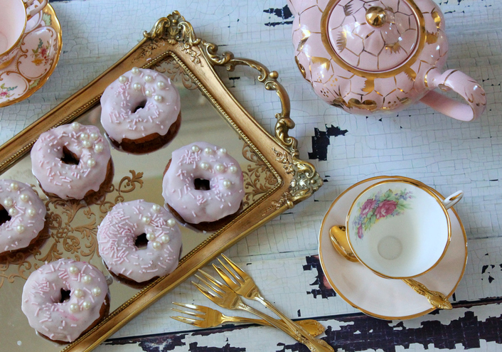 Vintage tea cups with iced donuts on a gold tray - tea party