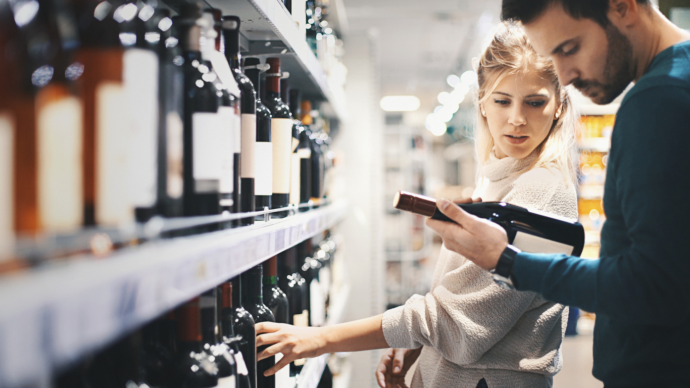 Couple buying some wine at a supermarket.