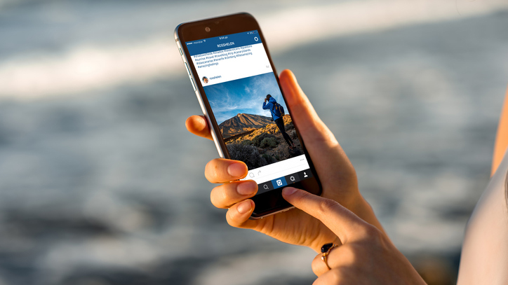 Woman watching Instagram news with new iPhone